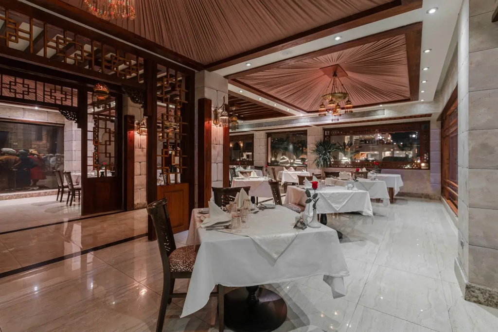 صورة: Gravity Hotel & Aqua Park Hurghada  Families and Couples Only: A spacious dining room with white-clothed tables, place settings, and decorative chandeliers.