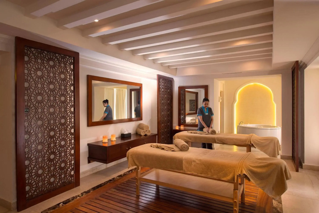 Baron Palace Sahl Hasheesh Resort: A warm, softly lit spa treatment room with two massage tables and a bathtub.