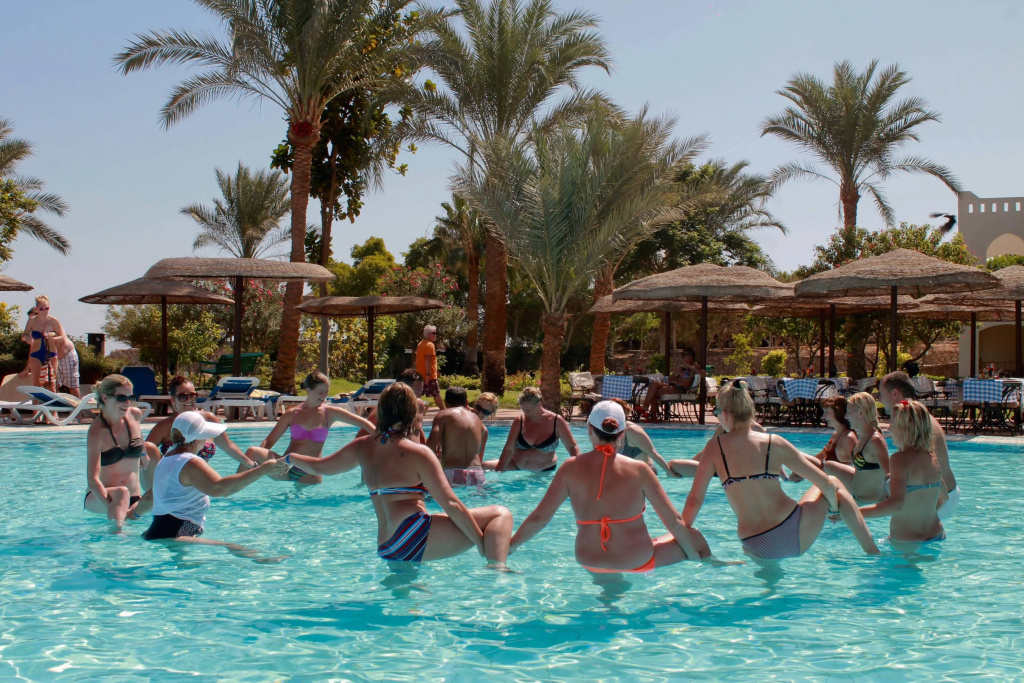 Pickalbatros Royal Grand Sharm - Adults Friendly 16 Years Plus: Guests gather in a palm-lined outdoor pool, with sun loungers and shaded seating along the deck.