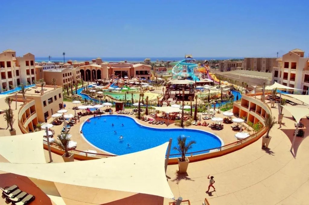 Coral Sea Aqua Club: Outdoor pools and colorful water slides are surrounded by sun loungers and hotel buildings.