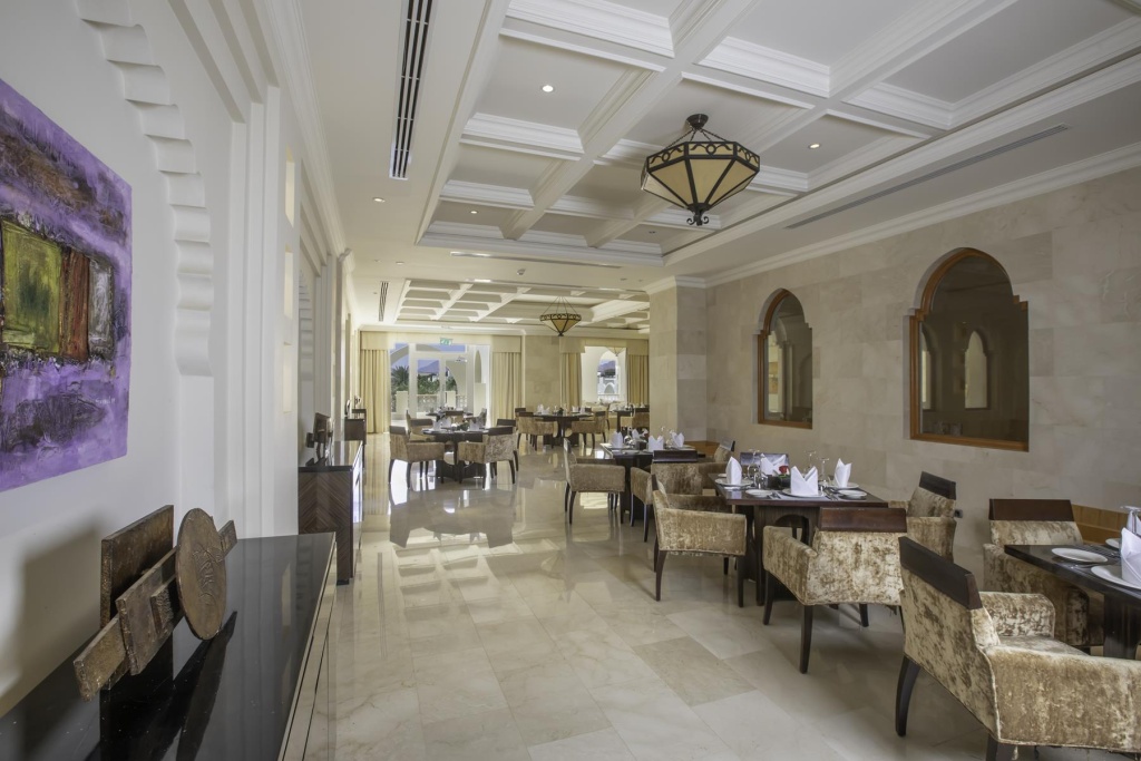 Swissôtel Sharm El Sheikh All Inclusive Collection: An elegant dining room with neatly set tables, upholstered chairs, and warm decorative lighting.