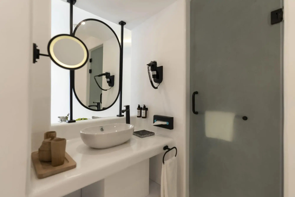 Meraki Resort Sharm El Sheikh: Bathroom vanity with a vessel sink, large mirror, toiletries, and a wall-mounted hair dryer.