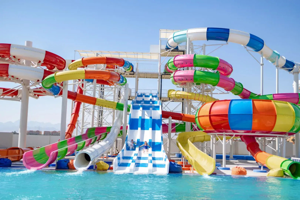 Mövenpick Waterpark Resort & Spa Soma Bay: A vibrant outdoor water park features a large swimming pool and a variety of colorful water slides.