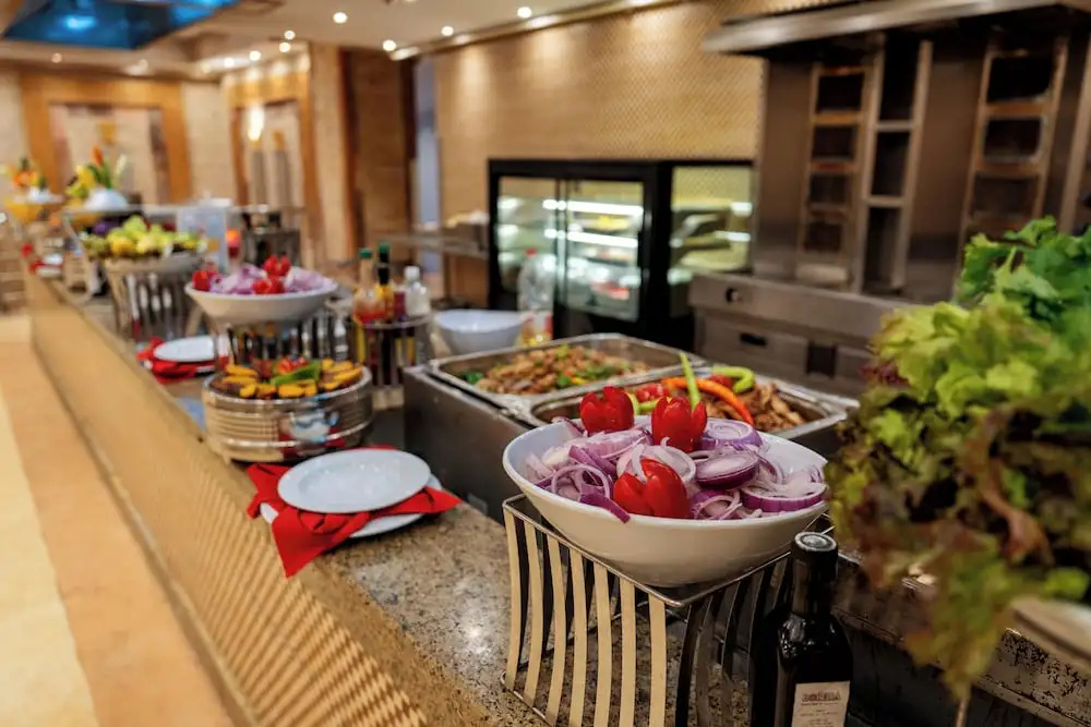 Rewaya Inn Resort: A bright buffet area features prepared dishes, fresh vegetables, and salad toppings across several serving stations.