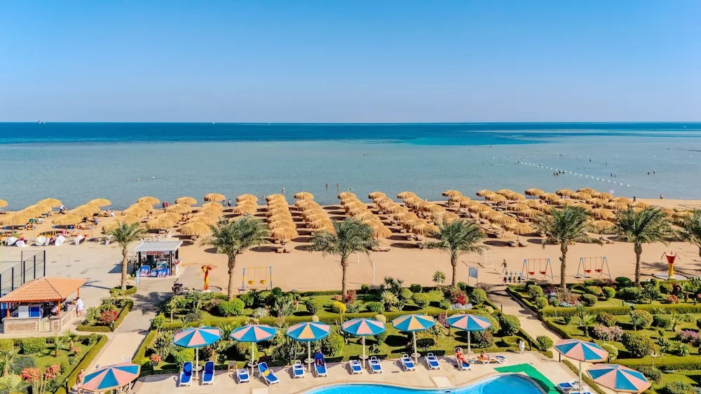 Rewaya Inn Resort: Relax by the outdoor pool or unwind on the sandy beach beneath rows of thatched umbrellas.