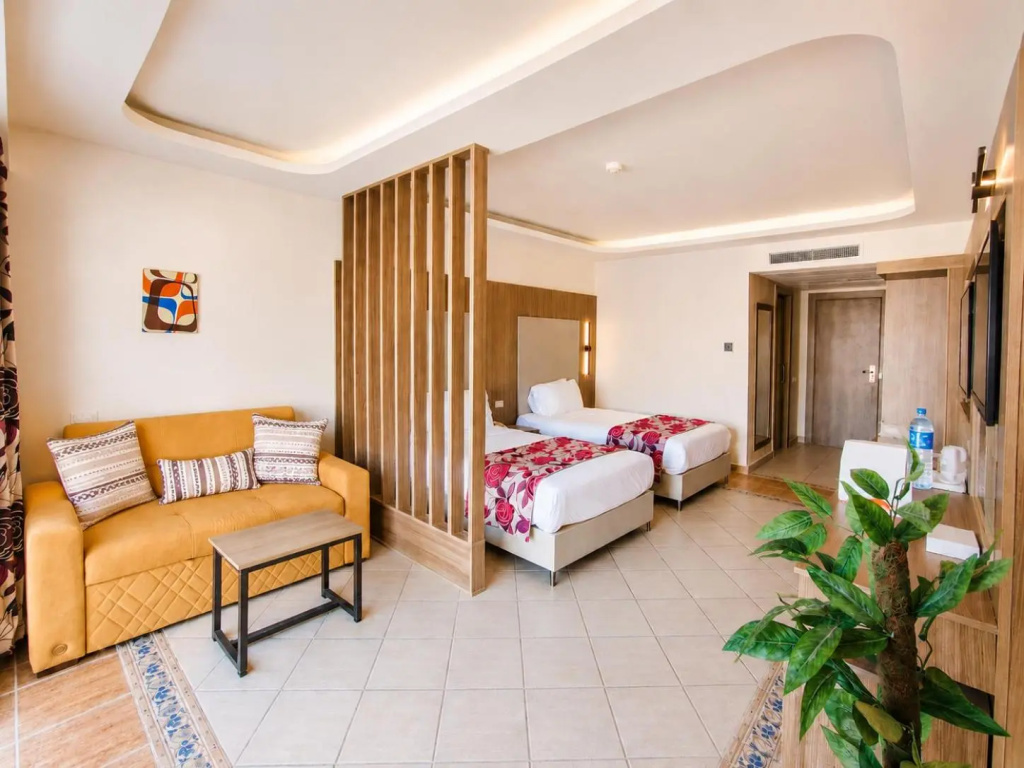 Royal Regency Club - Ultra All Inclusive: A bright room with two single beds and a comfortable sofa seating area.
