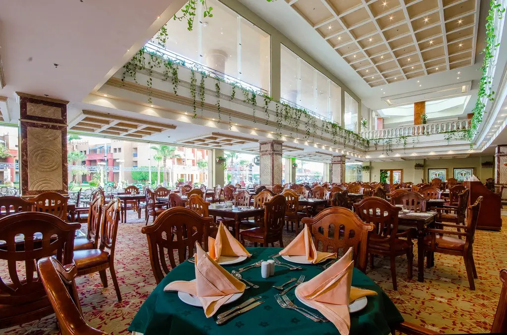 Titanic Beach - Families and Couples only: A spacious restaurant dining room with set tables, ornate wooden chairs, and an airy atrium.