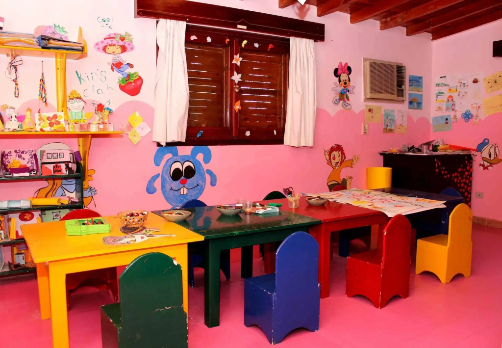 Coral Beach Resort: A colorful children’s activity room with child-sized tables, chairs, toys, and playful wall decorations.
