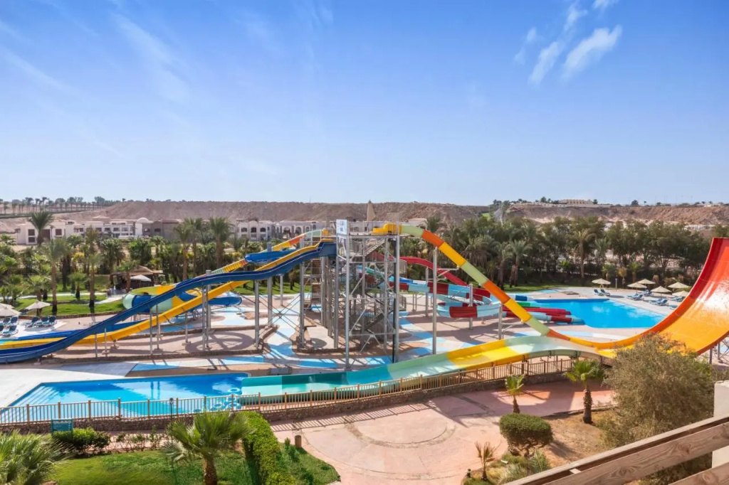 Xperience Kiroseiz Premier: Colorful water slides wind around outdoor pools, with sun loungers and palm trees nearby.