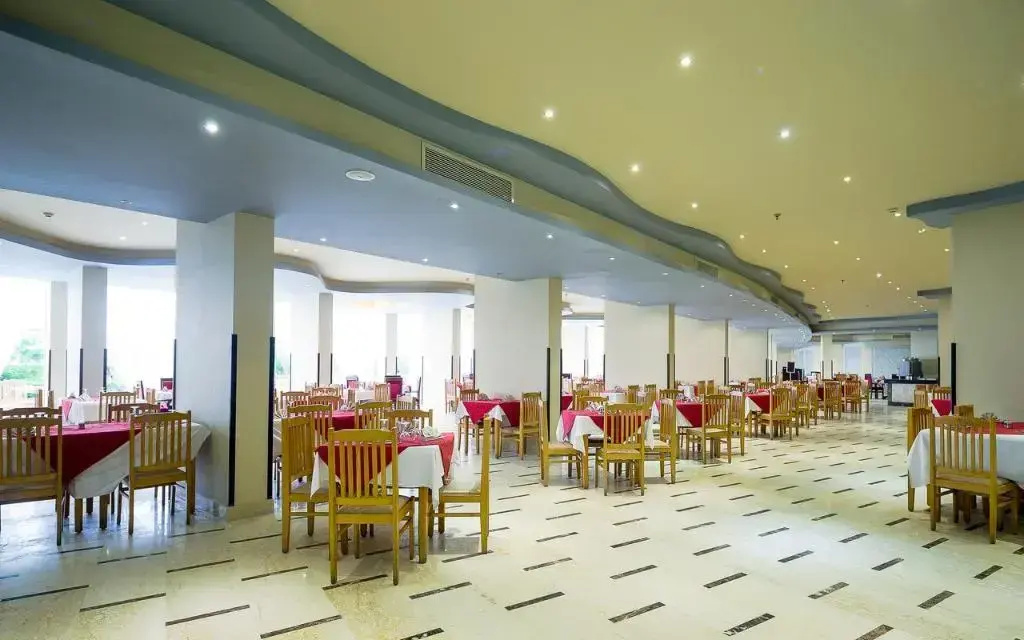 SUNRISE Solara Aqua park Resort: Spacious indoor dining room with rows of tables and wooden chairs.