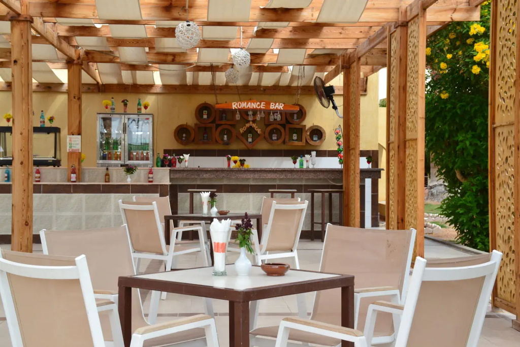 Romance Regency Club Adult Only (+16) - Ultra All Inclusive: A covered open-air dining area with tables and chairs beside the Romance Bar.