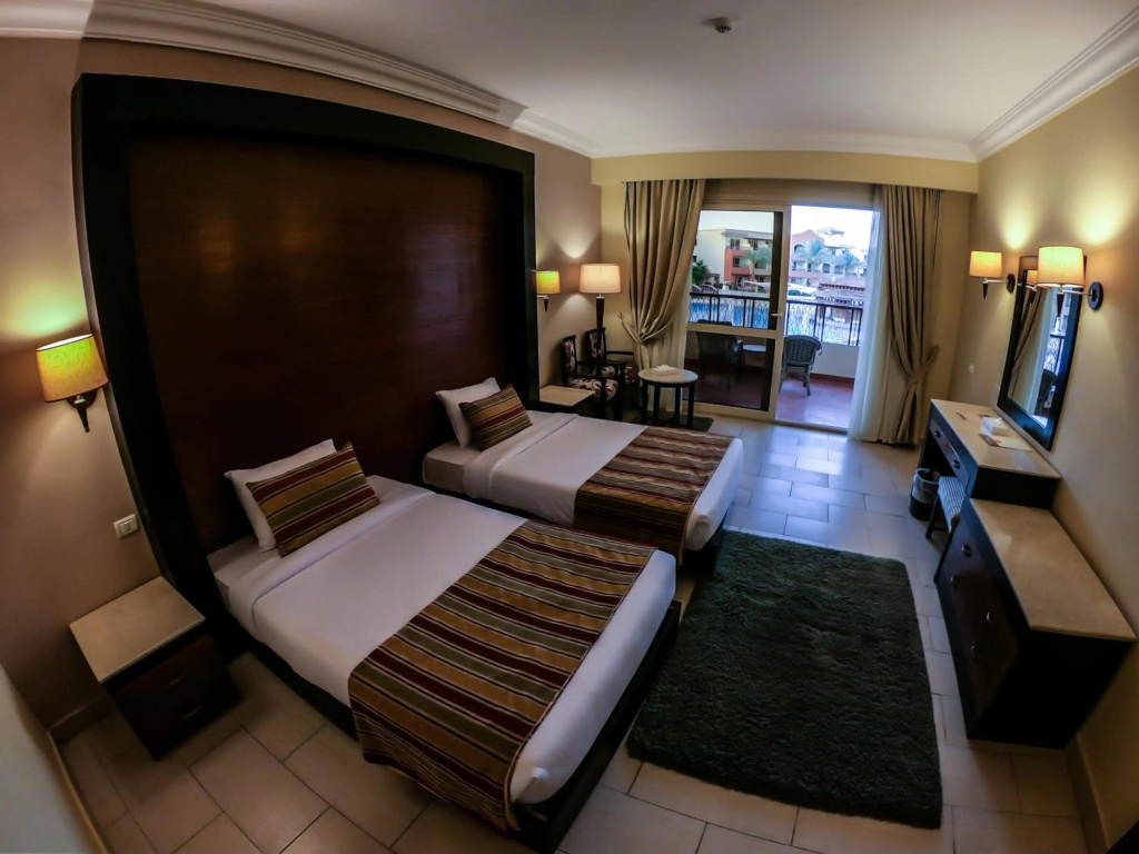 Regency Plaza Aqua Park & SPA: Twin guest room with two beds, a writing desk, and glass doors opening onto a furnished balcony.