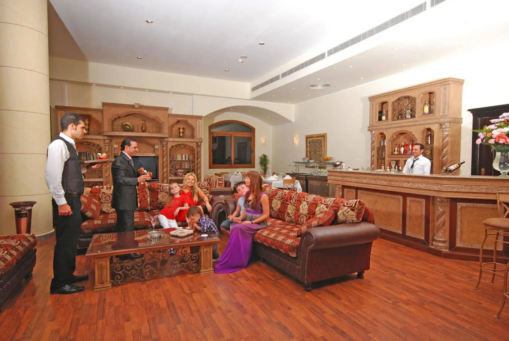 Nubian Island, Families and Couples only: A spacious lounge with patterned sofas, a coffee table, and a staffed bar.