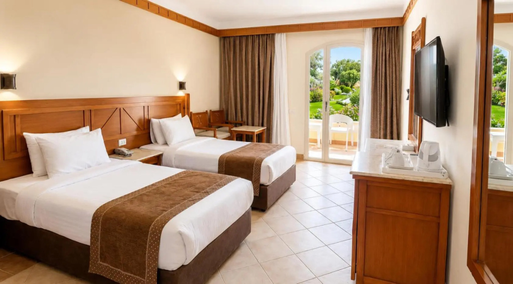Romance Regency Club Adult Only (+16) - Ultra All Inclusive: A bright twin room with two beds, a flat-screen TV, and doors opening to a garden-facing balcony or terrace.