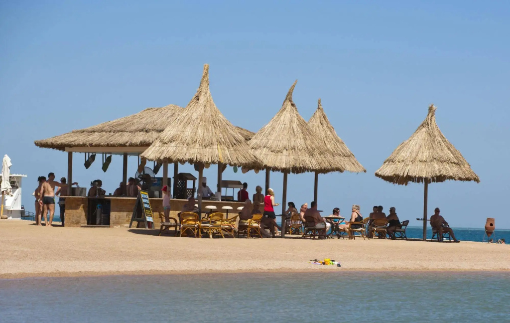 Siva Grand Beach: An open-air beach bar with thatched shade, outdoor seating, and ocean views.