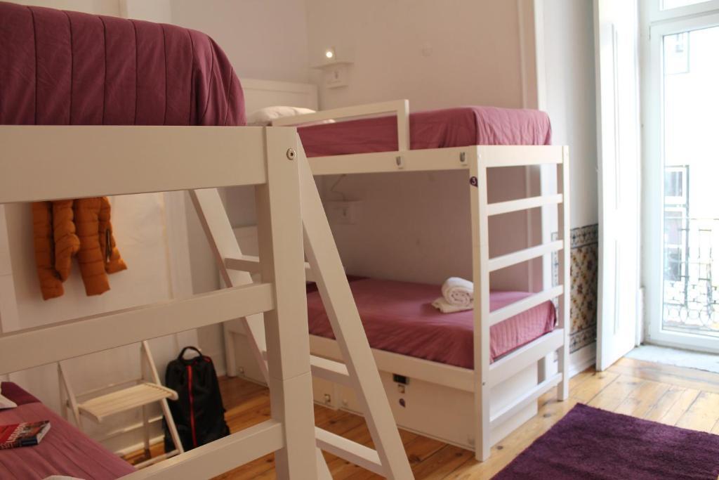 Кровать в общем номере с красивым видом из окна в Lost Inn Lisbon Hostel