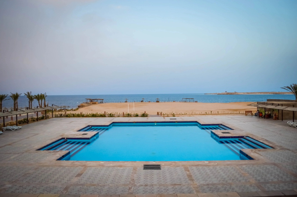 Viva Blue Resort and Diving Sharm El Naga (Adults Only): A large outdoor swimming pool sits on a broad tiled deck overlooking the sea.