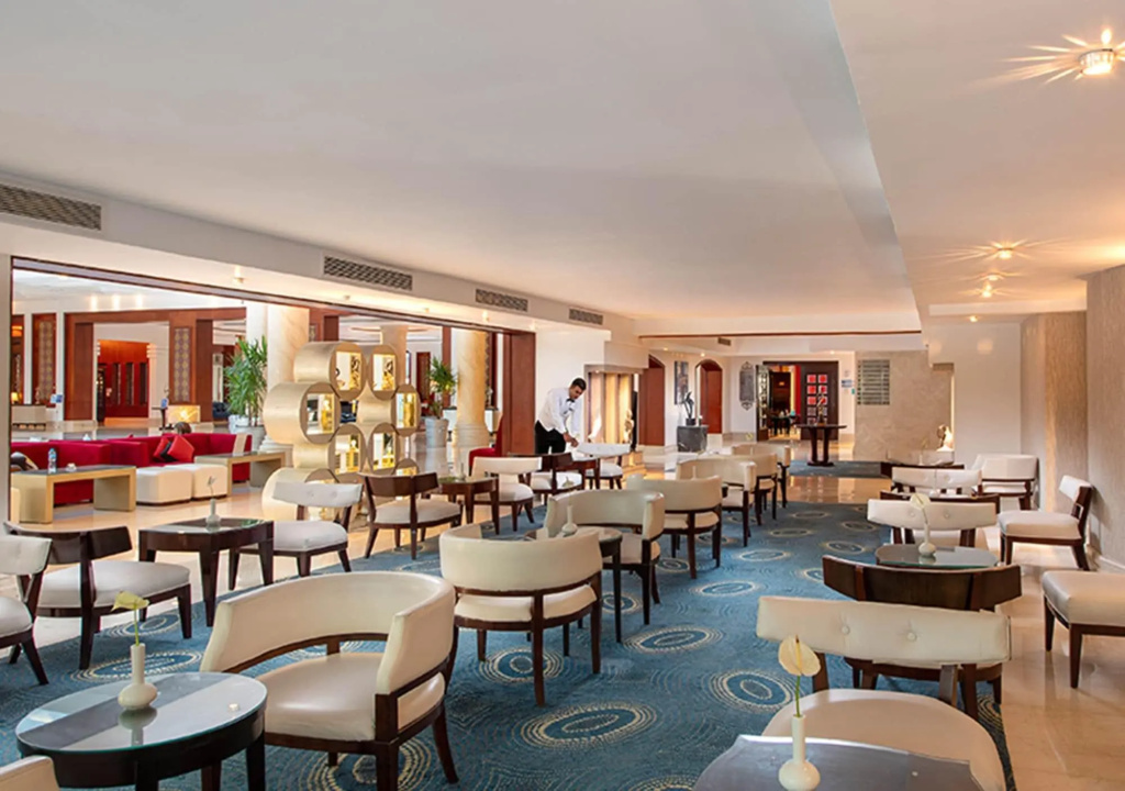 صورة: Premier Le Reve Hotel & Spa Sahl Hashesh -Adults Only: A spacious lounge with varied upholstered seating, small tables, and patterned carpet.