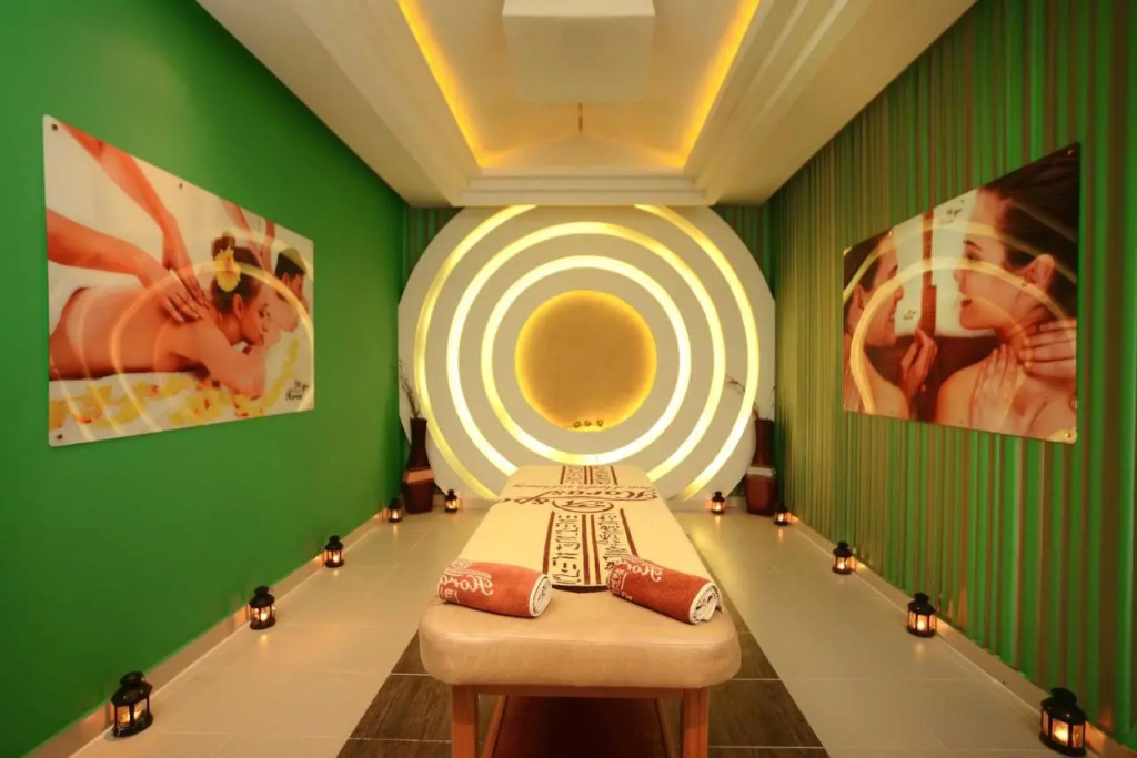 Pickalbatros Palace Resort - Hurghada: A softly lit spa treatment room with a padded massage table and rolled towels.