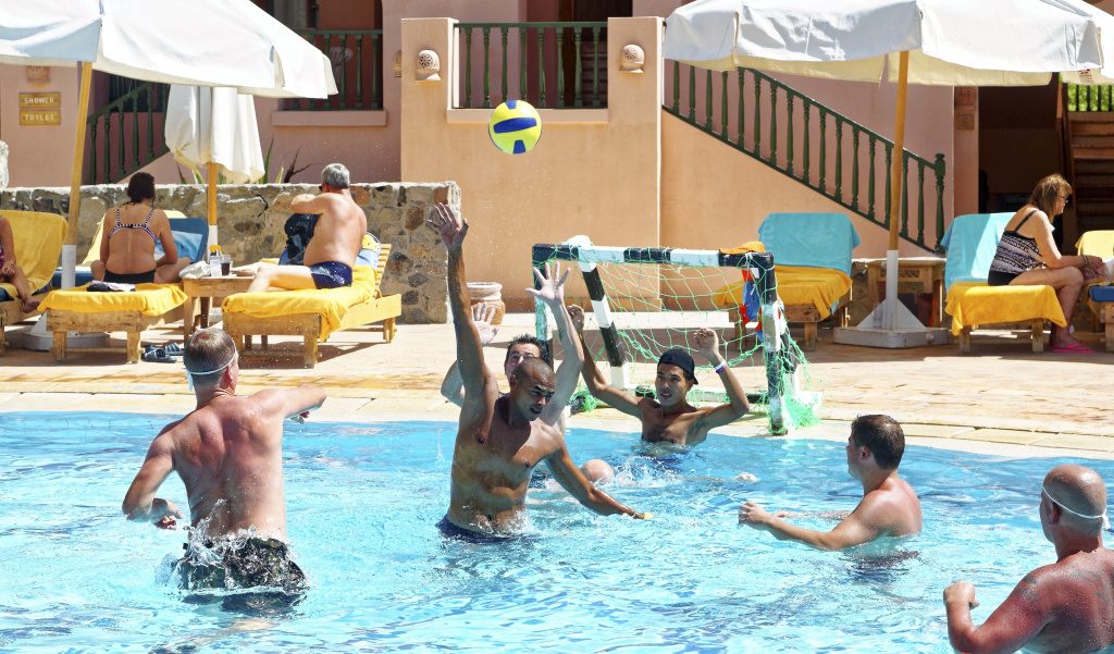 Three Corners Rihana Resort: Guests play in the outdoor pool while shaded sun loungers line the pool deck.