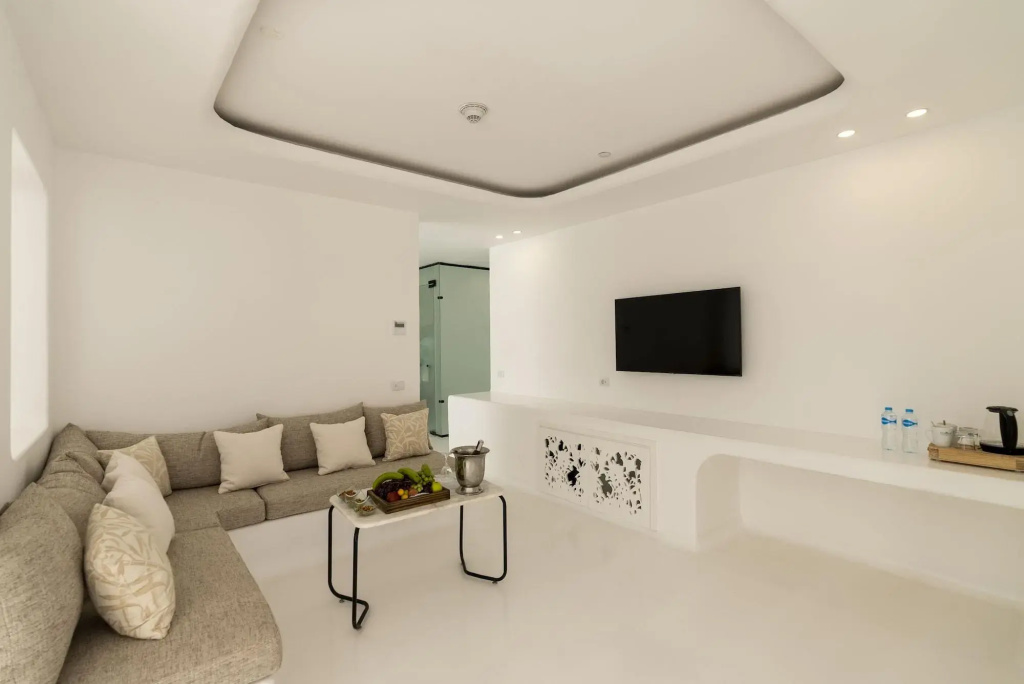 Meraki Resort Sharm El Sheikh: Relax in a bright lounge with a spacious sectional sofa, wall-mounted TV, and a kettle station.