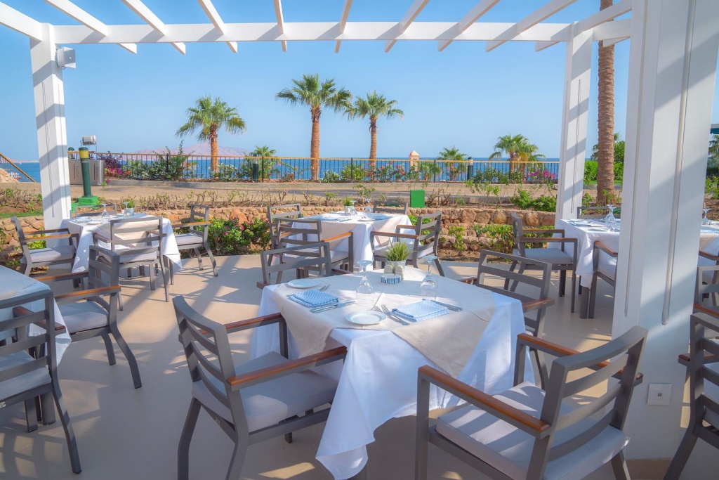 Savoy Sharm El Sheikh hotel: Dine outdoors on a shaded terrace with views of the sea and palm trees.