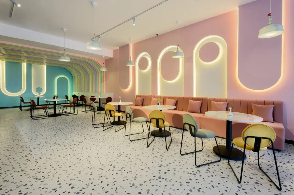 Flow Spectrum Resort Sahl Hasheesh: A colorful dining lounge with café tables, stools, and a long upholstered banquette.
