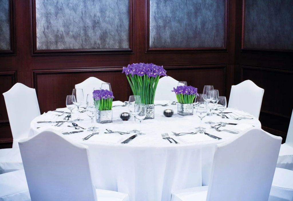 Mövenpick Waterpark Resort & Spa Soma Bay: A formal dining room set for a group meal, with white linens and purple floral centerpieces.