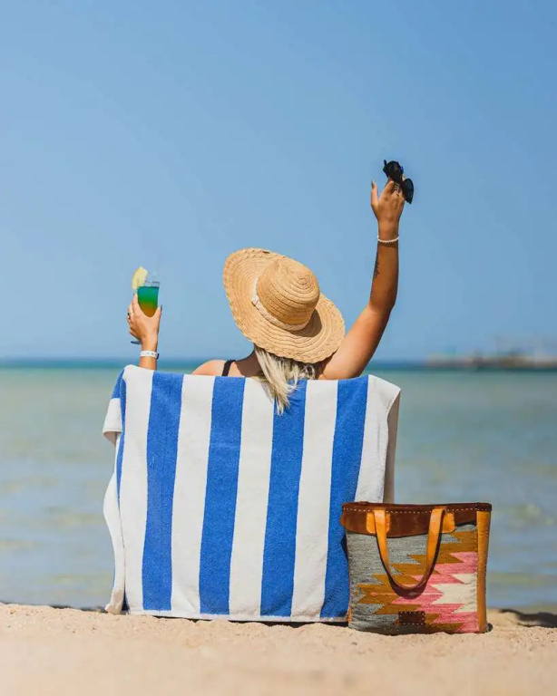 Titanic Palace - Families and Couples only: Relax on the sandy beach in a striped beach chair beside the calm sea.