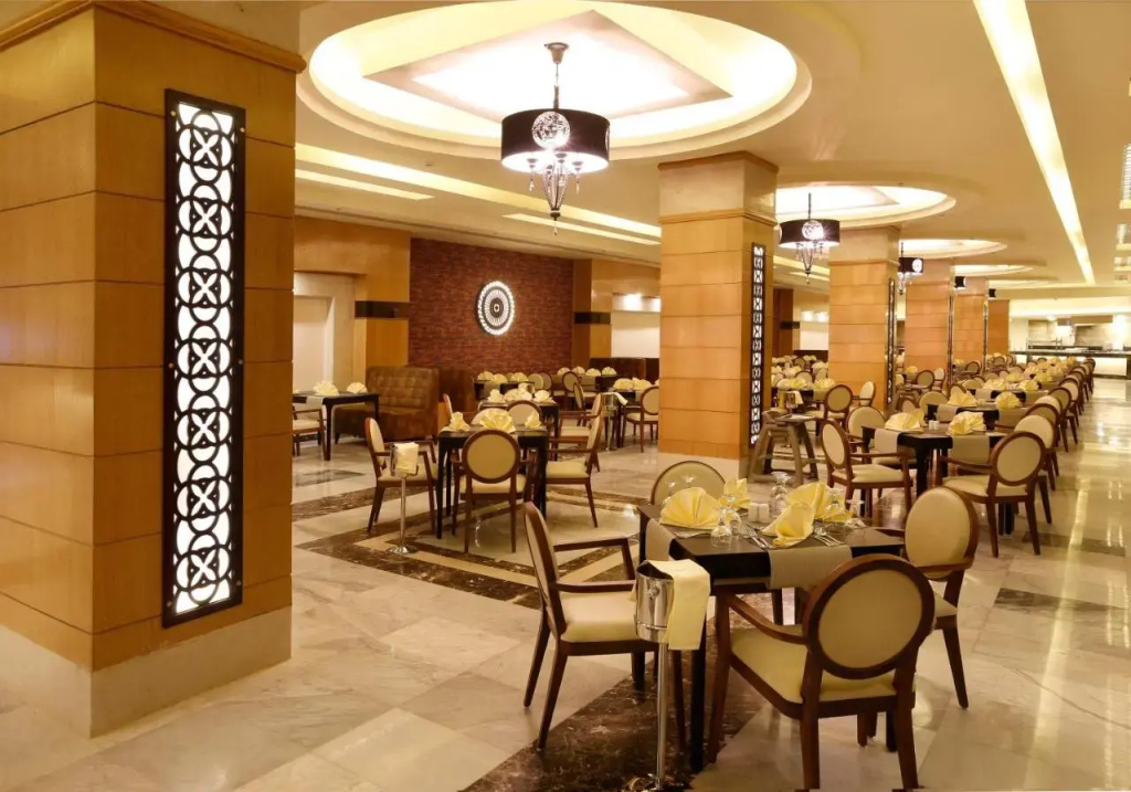 Pickalbatros Aqua Park Sharm El Sheikh: A spacious restaurant dining room with neatly set tables and warm, elegant lighting.