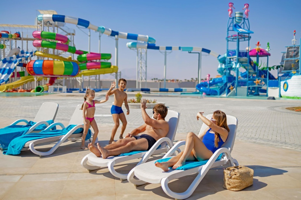 Mövenpick Waterpark Resort & Spa Soma Bay: Relax on sun loungers beside a colorful water park with family-friendly slides.