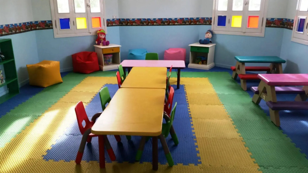 Albatros Makadi Resort: A bright children’s playroom with low tables, small chairs, toys, and colorful padded flooring.