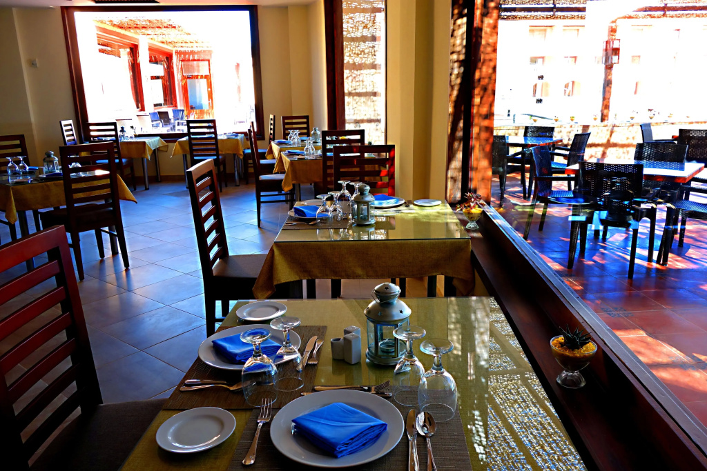 Viva Blue Resort and Diving Sharm El Naga (Adults Only): A bright restaurant dining room with neatly set tables and large windows.