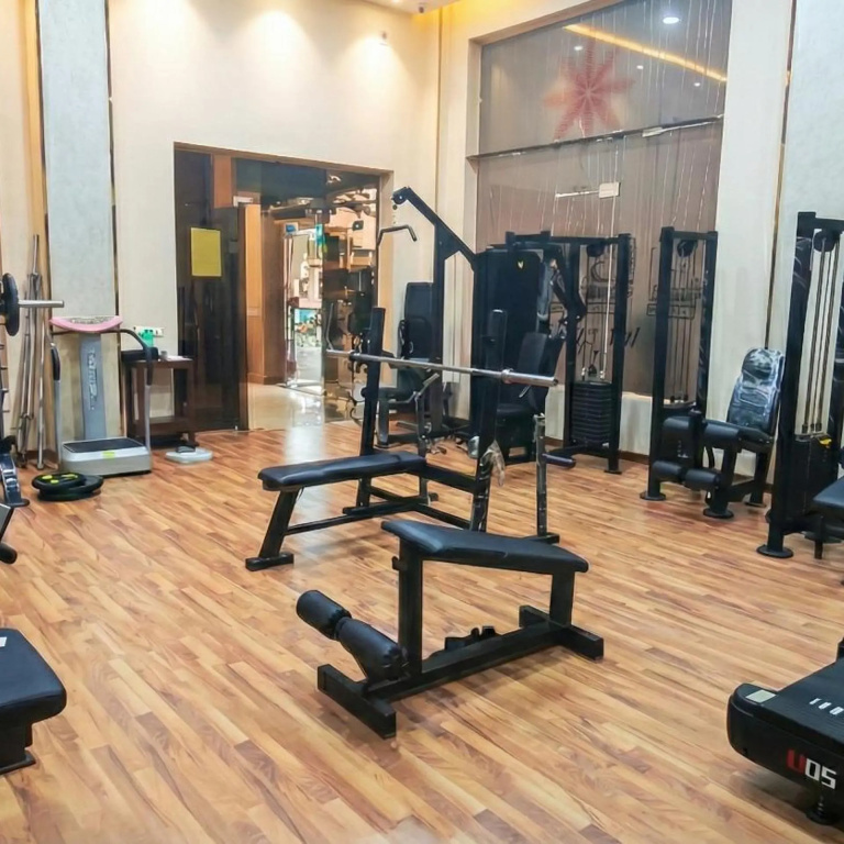 Romance Regency Club Adult Only (+16) - Ultra All Inclusive: Fitness room with weight-training machines, a bench press station, and wood-look flooring.