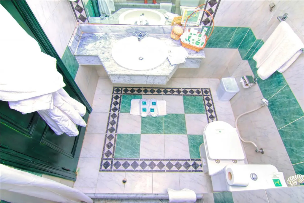 JAZ Palmariva Beach Resort: A bright tiled bathroom with a marble-look vanity, sink, toilet, fresh towels, and toiletries.