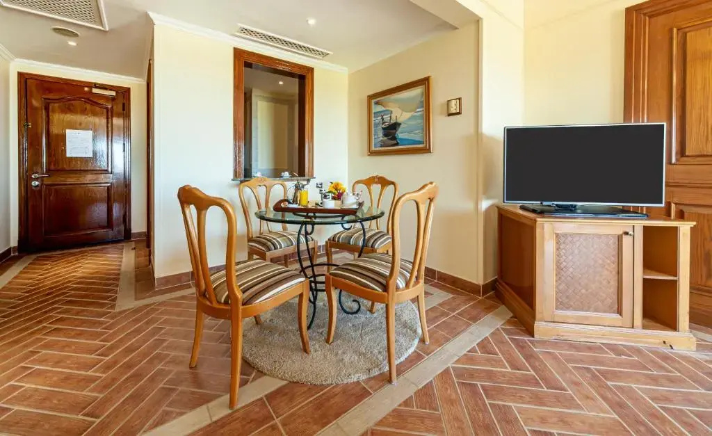 The Cascades Golf Resort Spa and Thalasso: A comfortable dining nook with a round table, four chairs, and a flat-screen TV.