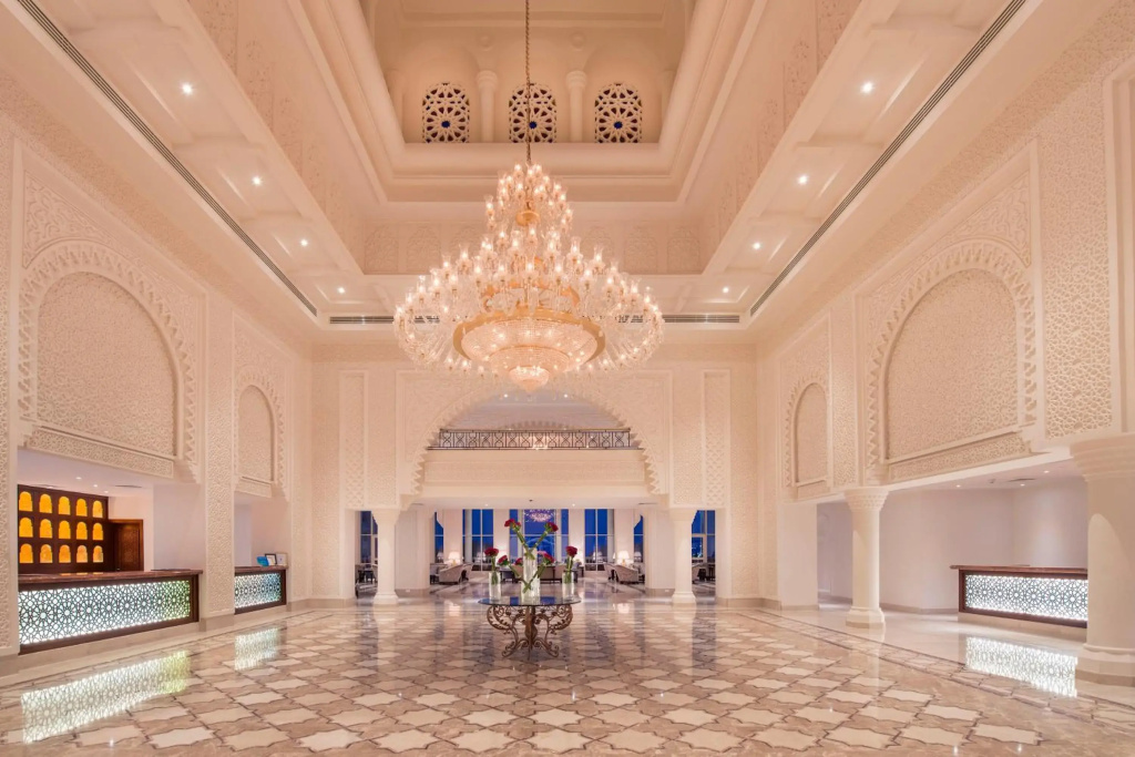 Baron Palace Sahl Hasheesh Resort: An expansive, ornate lobby features a grand chandelier, patterned stone flooring, and reception counters.