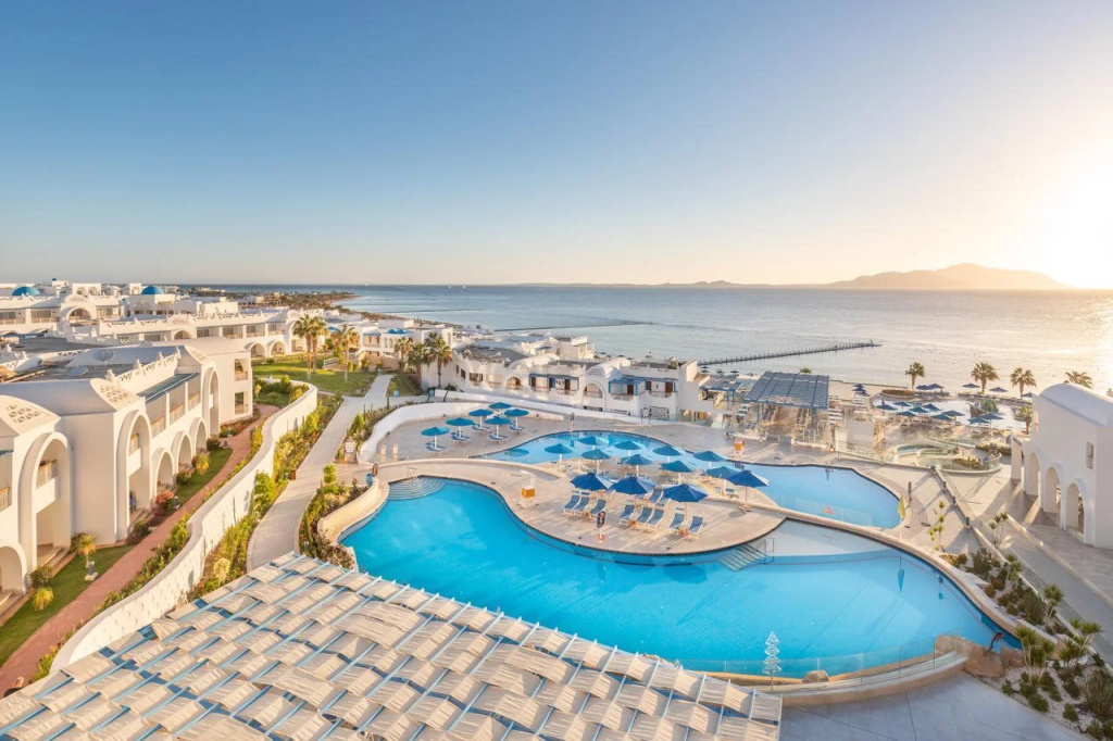 Pickalbatros Palace Resort - Sharm El Sheikh: A spacious resort pool complex with sun loungers and umbrellas, set beside the sea.