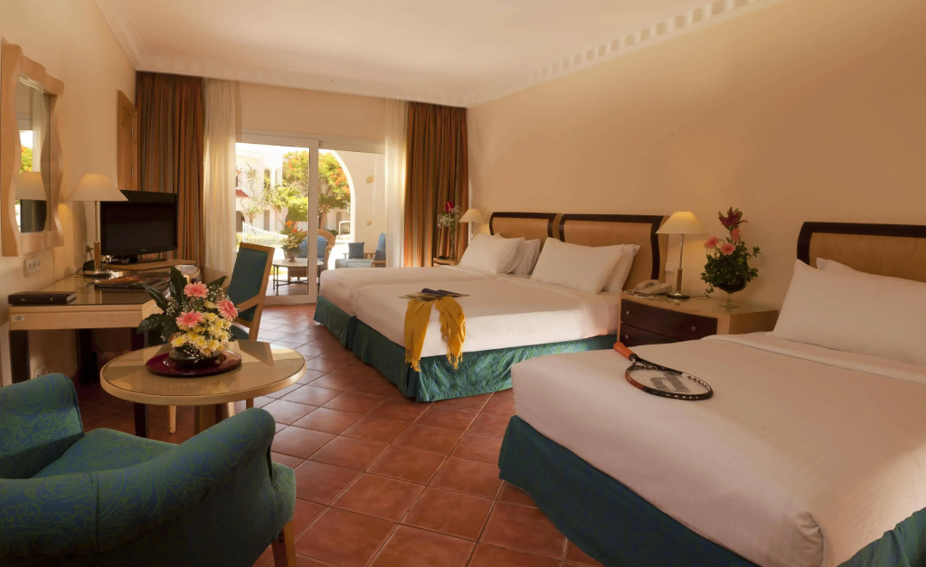 Savoy Sharm El Sheikh hotel: Guest room with two beds, a work desk, a sitting area, and sliding doors to an outdoor patio.