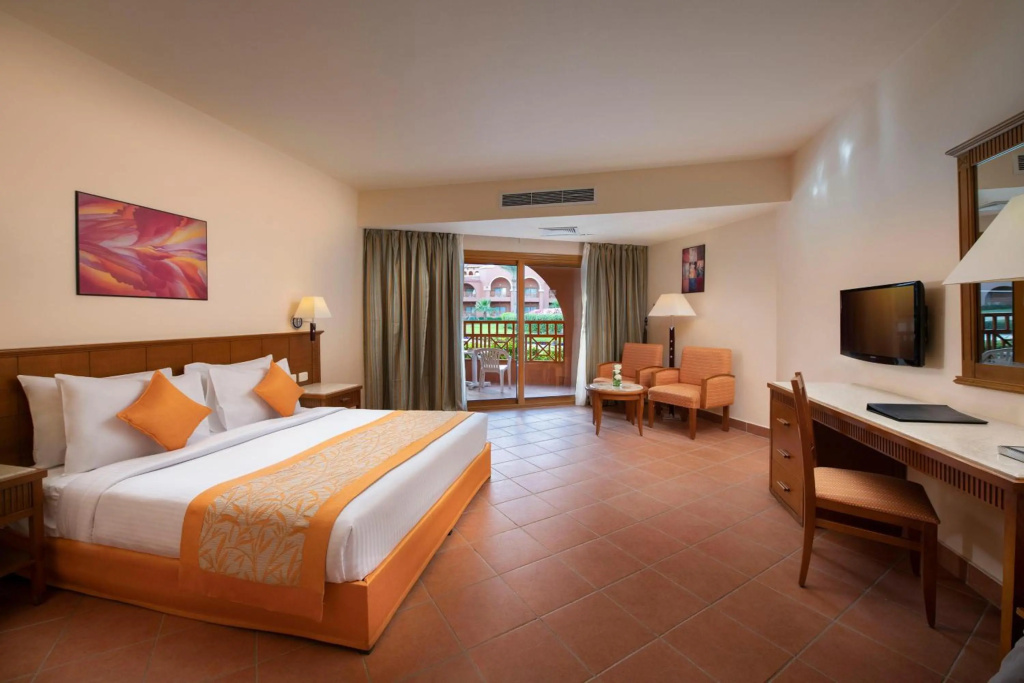 Charmillion Gardens Aquapark: A spacious guest room with a furnished balcony, desk, TV, and seating area.