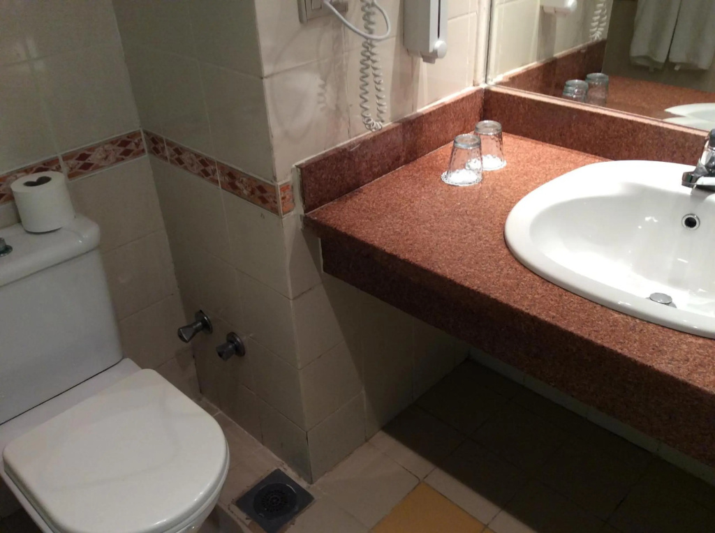 Panorama Naama Heights Sharm El Sheikh: Compact bathroom with a toilet, vanity sink, countertop, and mirror.