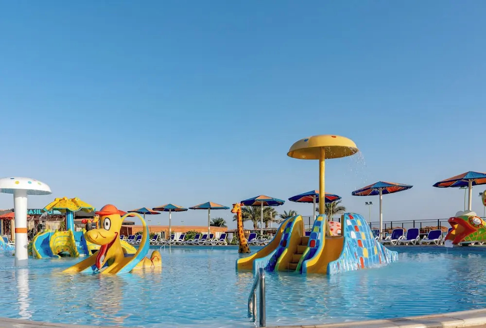 Rewaya Inn Resort: A colorful children’s pool features water slides, splash-play structures, and loungers along the deck.