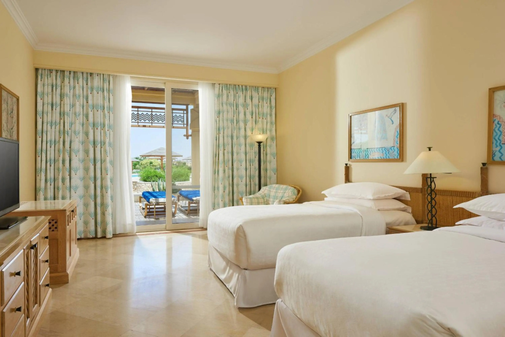 Sheraton Soma Bay Resort: A bright twin room with a furnished patio, two outdoor loungers, and a glimpse of the pool.