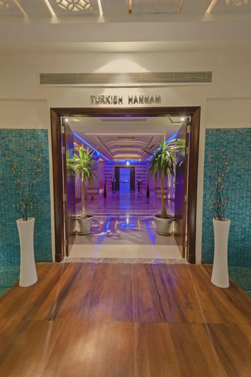 صورة: Premier Le Reve Hotel & Spa Sahl Hashesh -Adults Only: Entrance to a Turkish hammam, with a polished corridor and decorative plants.