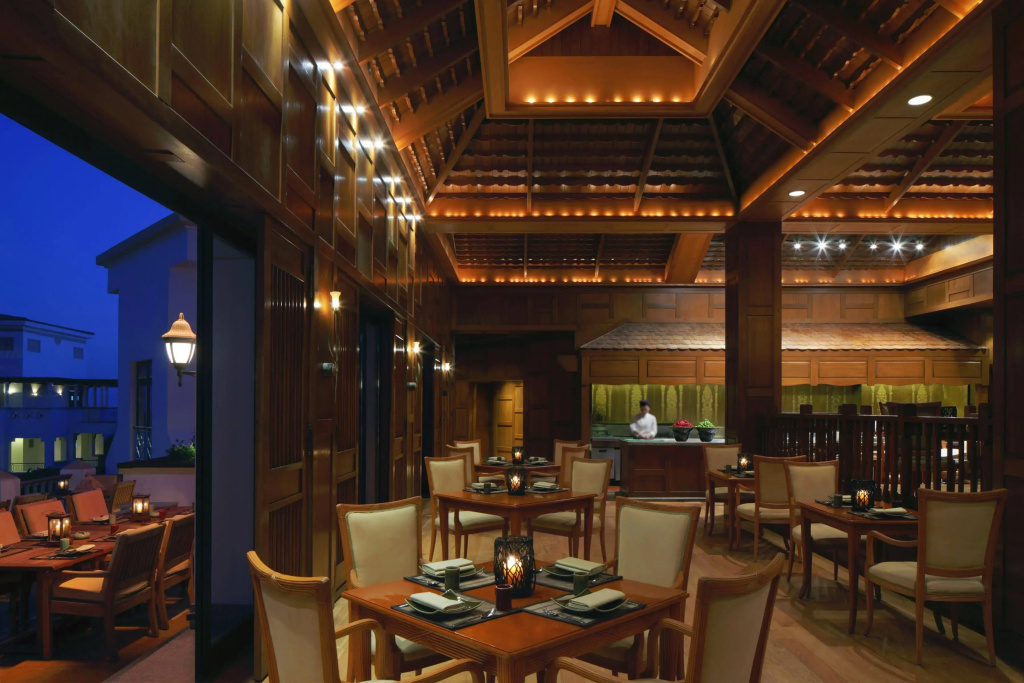 Park Regency Sharm El Sheikh Resort: A warmly lit wood-paneled restaurant with set dining tables and an adjoining outdoor seating area.
