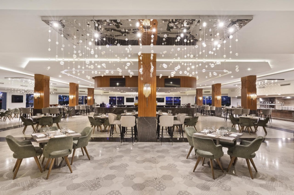 Pickalbatros Palace Resort - Sharm El Sheikh: A spacious restaurant dining room with elegant chandeliers, wood accents, and tables set for guests.