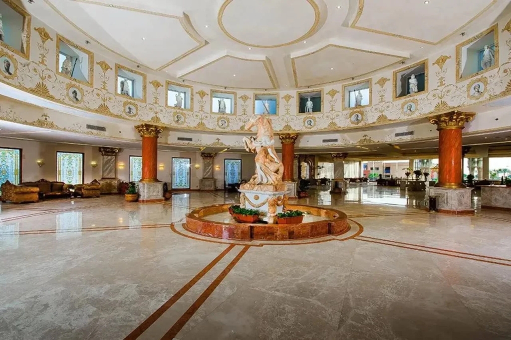 Titanic Palace - Families and Couples only: A grand hotel lobby features a decorative central fountain, polished floors, ornate columns, and lounge seating.