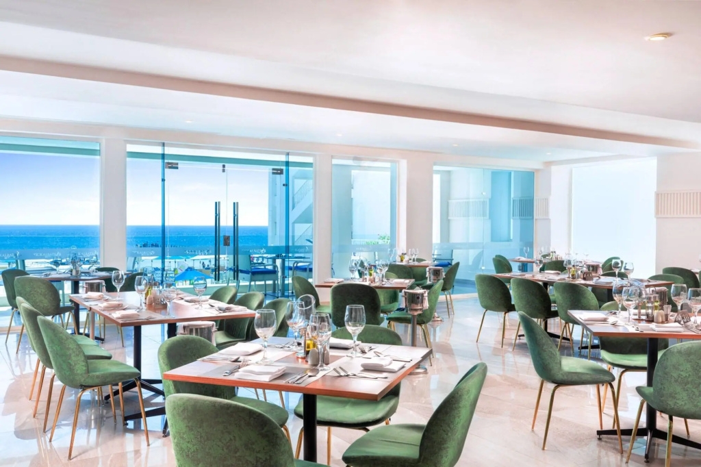 Pickalbatros Palace Sharm & Aqua Park: Bright restaurant dining room with green upholstered chairs and expansive sea views.