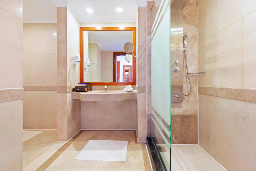 Pickalbatros Palace Resort - Sharm El Sheikh: Bright marble bathroom with a vanity, large mirror, and glass-enclosed shower.