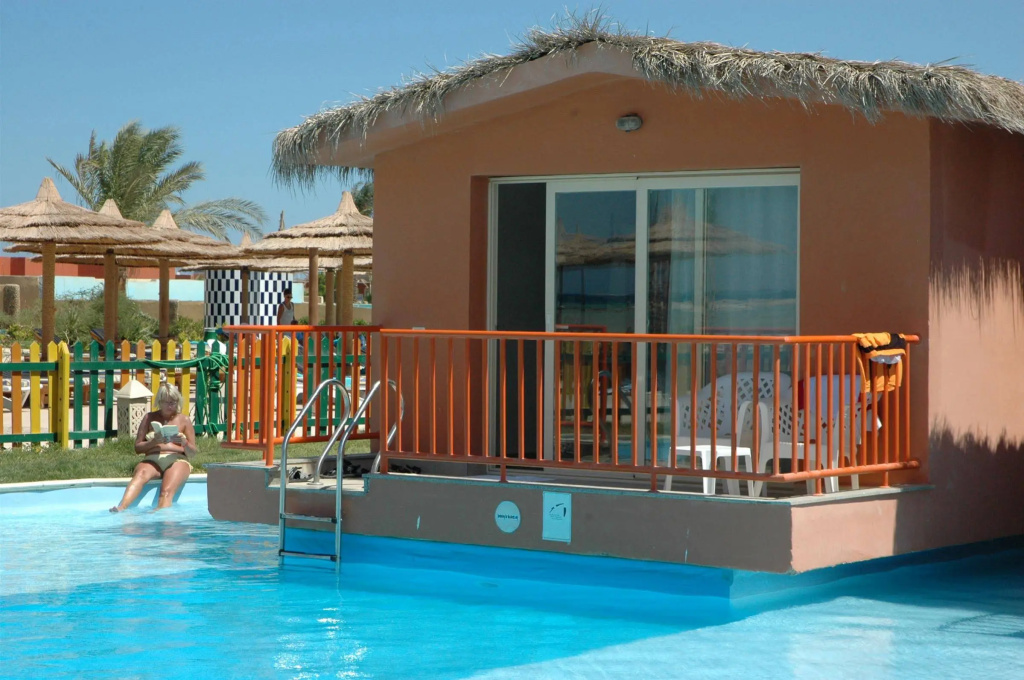 Titanic Palace - Families and Couples only: A bright outdoor pool sits beside a thatched-roof bungalow with a private-looking, railed terrace.